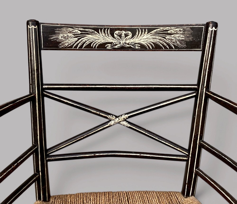 A Regency dark-painted wooden elbow chair featuring hand-painted white line decoration, an X-back splat, and a woven rush seat. View IV