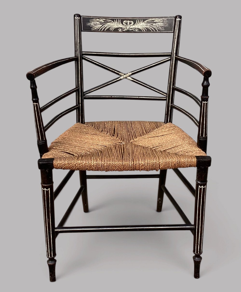 A Regency dark-painted wooden elbow chair featuring hand-painted white line decoration, an X-back splat, and a woven rush seat. View VIII