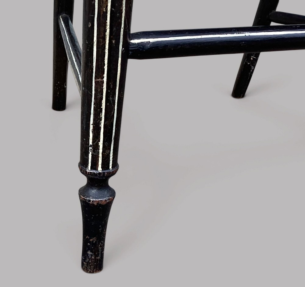A Regency dark-painted wooden elbow chair featuring hand-painted white line decoration, an X-back splat, and a woven rush seat. View XIV
