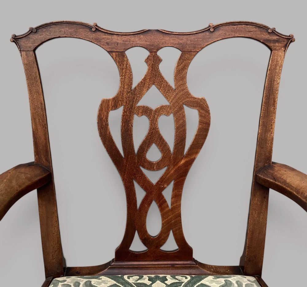 A George III mahogany open armchair featuring a carved pierced back splat, curved armrests, and a patterned fabric seat. View III