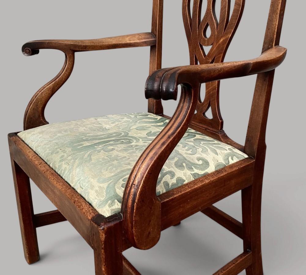 A George III mahogany open armchair featuring a carved pierced back splat, curved armrests, and a patterned fabric seat. View IV