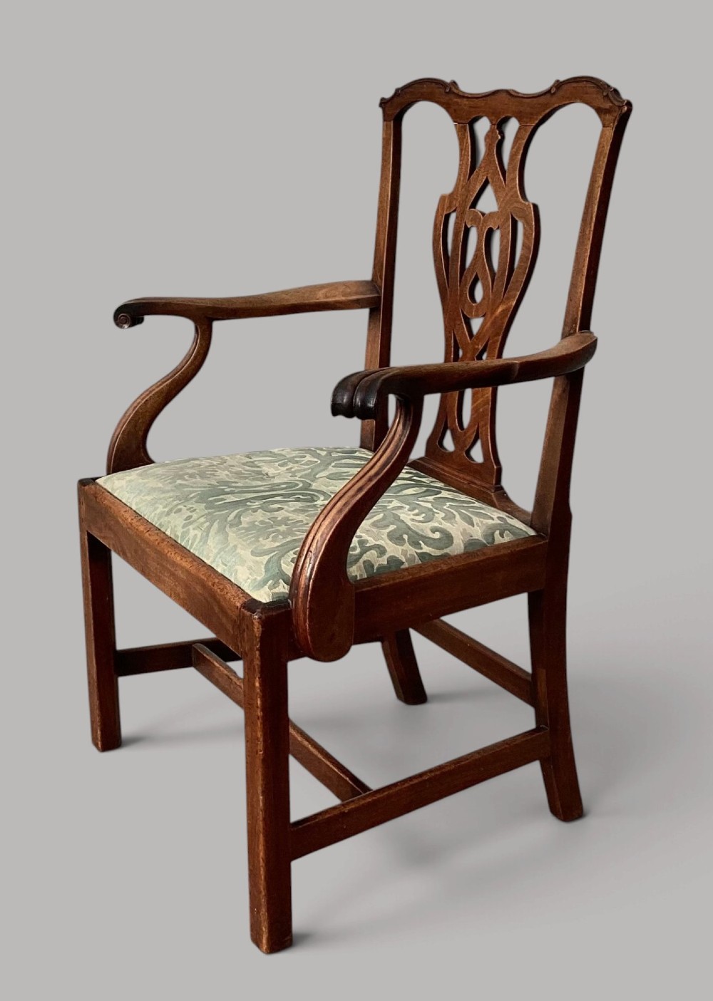 A George III mahogany open armchair featuring a carved pierced back splat, curved armrests, and a patterned fabric seat. View VI