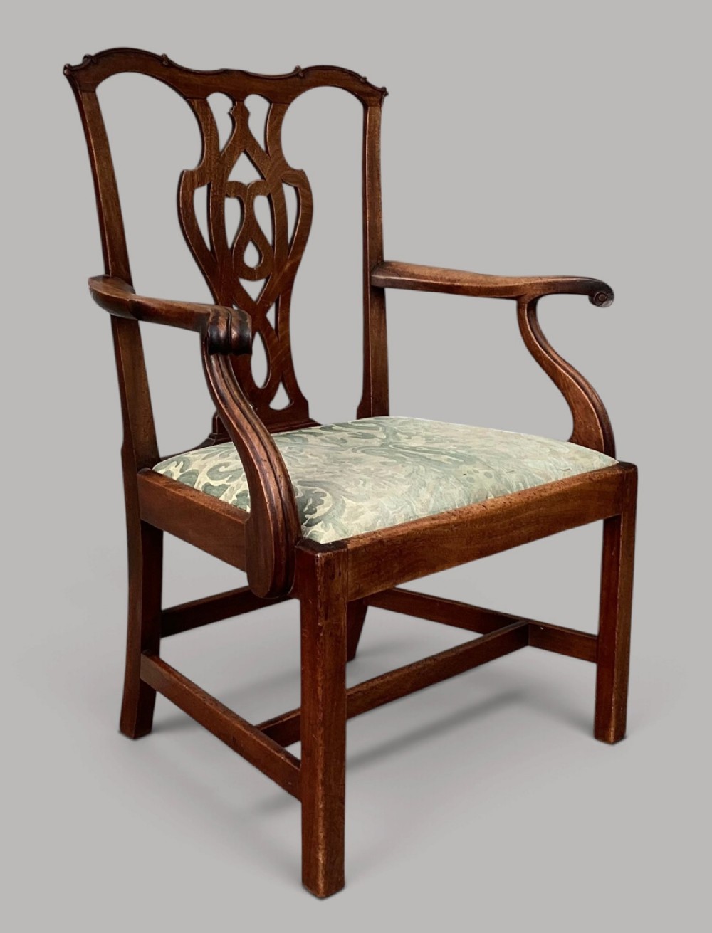 A George III mahogany open armchair featuring a carved pierced back splat, curved armrests, and a patterned fabric seat. View VII