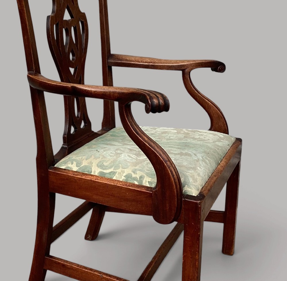 A George III mahogany open armchair featuring a carved pierced back splat, curved armrests, and a patterned fabric seat. View XII