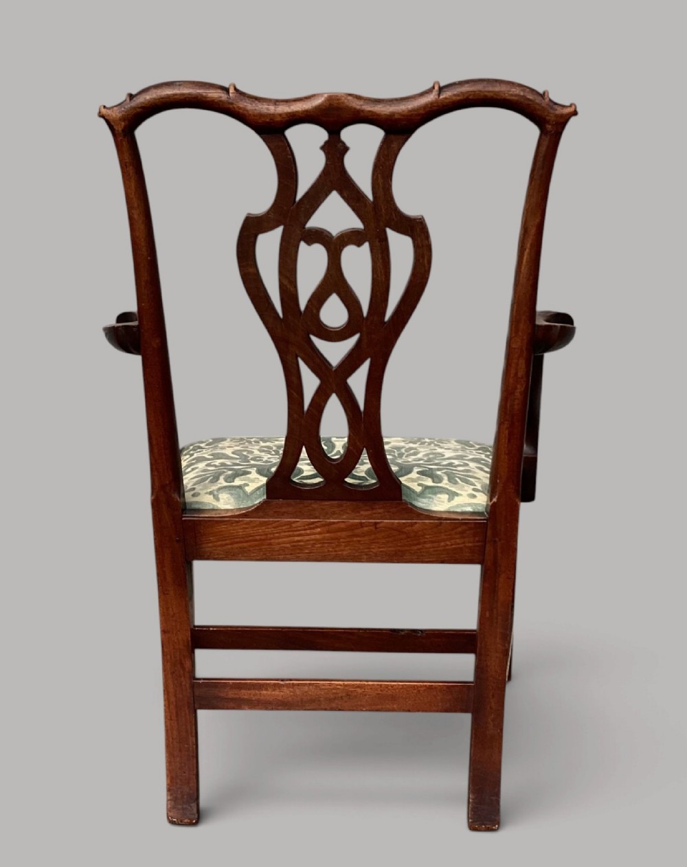 A George III mahogany open armchair featuring a carved pierced back splat, curved armrests, and a patterned fabric seat. View XV