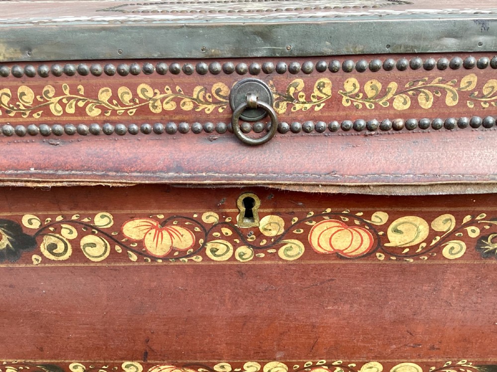 A 19th-century Chinese export camphor trunk bound in red leather with brass studding, gilded floral borders, and side carrying handles. View XIV