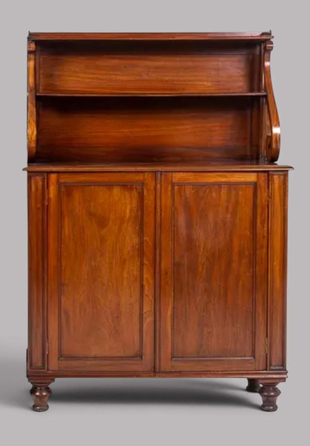 A matching pair of Regency mahogany side cabinets featuring panelled cupboard doors and tiered upper shelves supported by carved scroll uprights. View VI