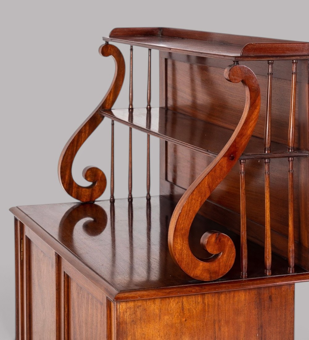 A matching pair of Regency mahogany side cabinets featuring panelled cupboard doors and tiered upper shelves supported by carved scroll uprights. View VIII