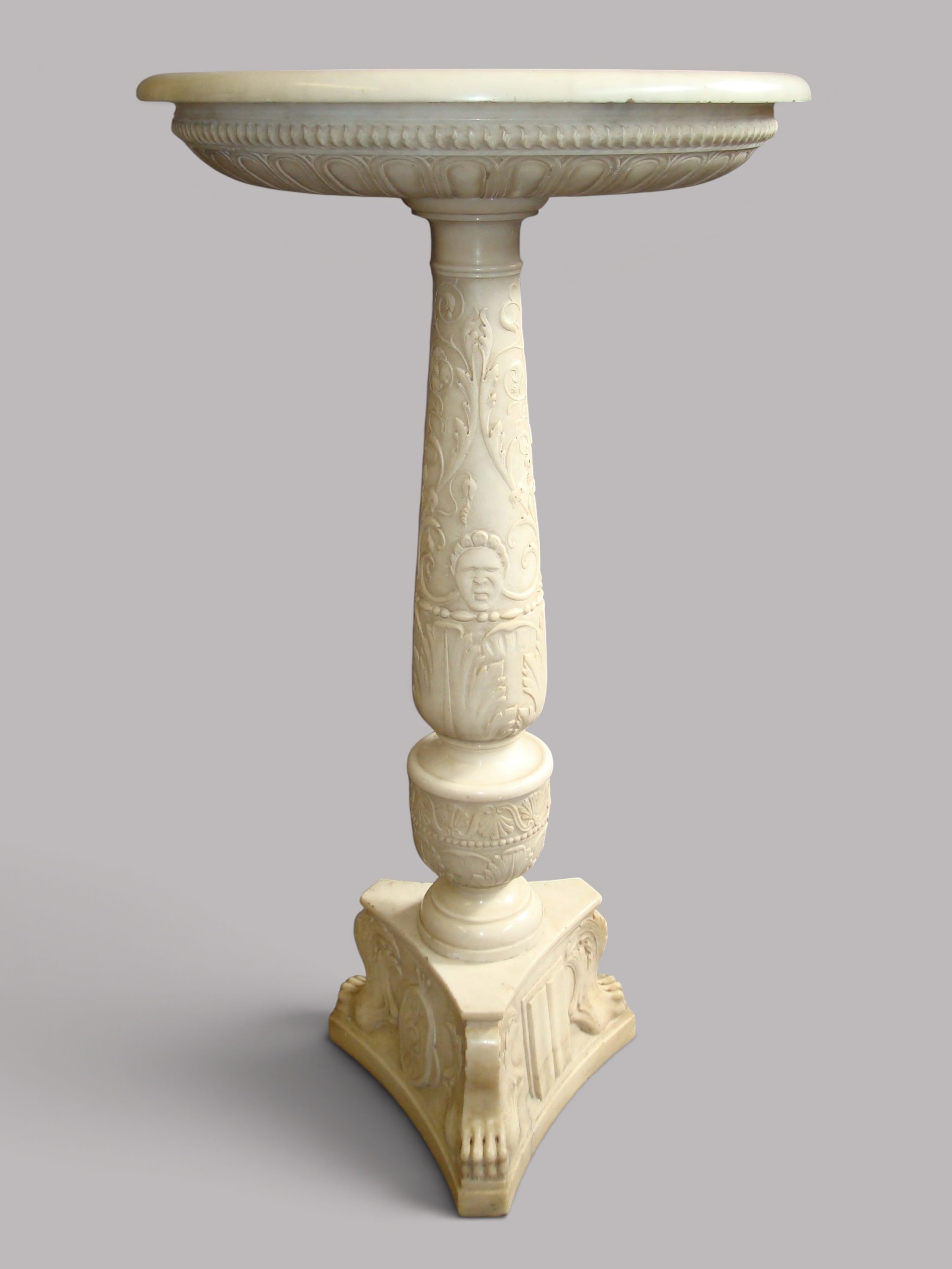 An early 19th-century Italian carved off-white marble tazza bowl resting on a relief-carved column pedestal with a triform base.