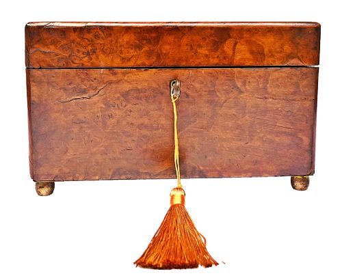 fig 1. A rectangular mid-Victorian tea caddy crafted from figured burr walnut veneer with a central brass keyhole escutcheon and key.