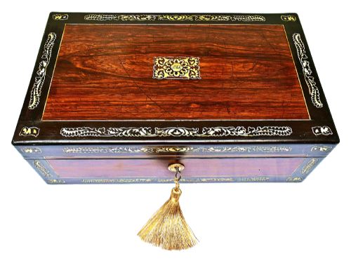 fig 2. A dark rosewood writing slope with intricate mother-of-pearl floral inlays along the borders and a brass key with tassel attached to the front lock.
