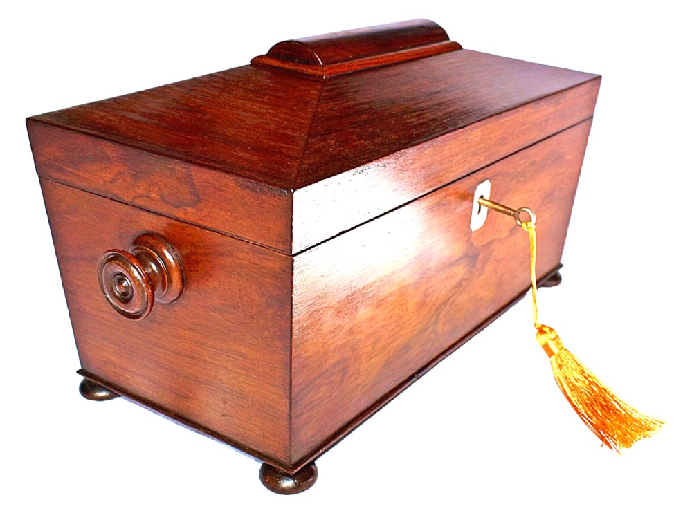 An open William IV sarcophagus-shaped dark wood tea caddy containing two lidded canisters and a central glass mixing bowl. View IV