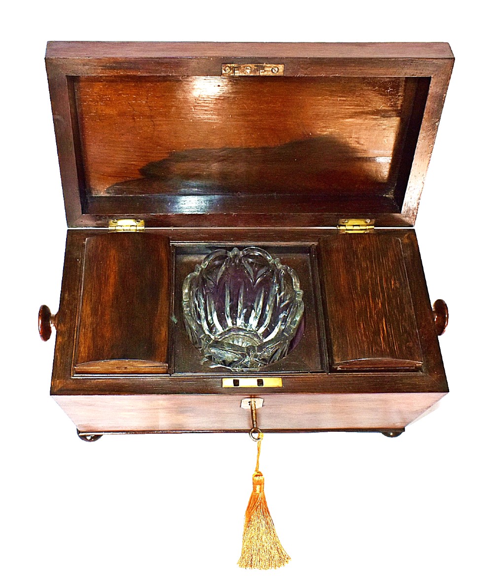 An open William IV sarcophagus-shaped dark wood tea caddy containing two lidded canisters and a central glass mixing bowl. View VII