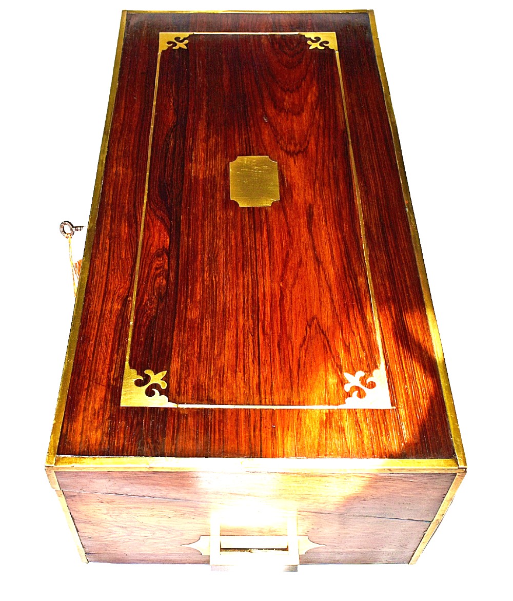 An open antique mahogany writing slope featuring a red gold-tooled leather writing surface, brass corner mounts, and dedicated compartments for inkwells. View V