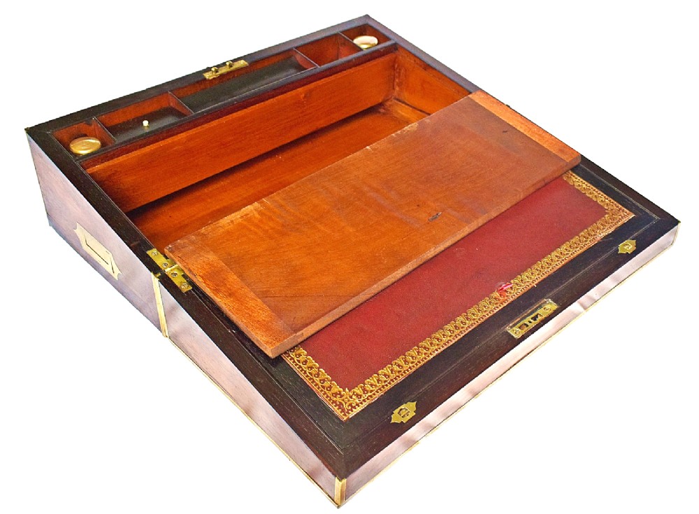 An open antique mahogany writing slope featuring a red gold-tooled leather writing surface, brass corner mounts, and dedicated compartments for inkwells. View IX