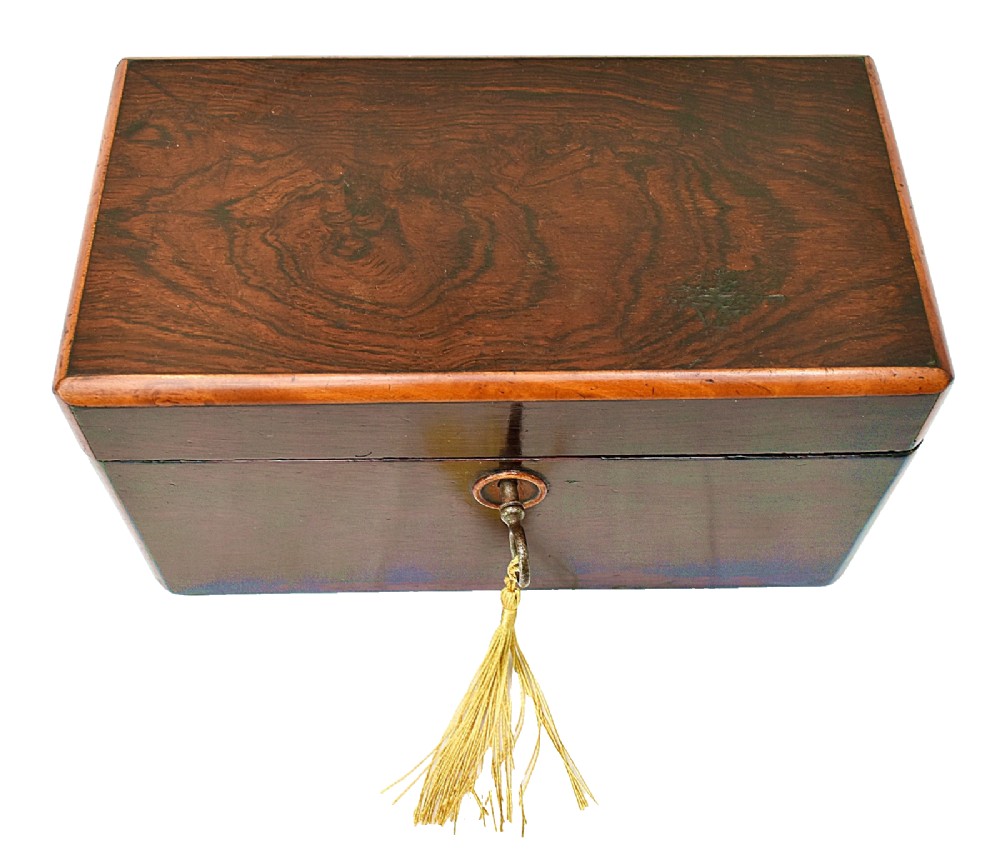 An open dark wood William IV tea caddy featuring two internal lidded compartments, a red embossed paper lining inside the lid, and a brass key with a tassel inserted in the lock. View IV