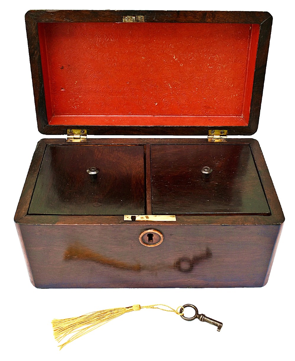An open dark wood William IV tea caddy featuring two internal lidded compartments, a red embossed paper lining inside the lid, and a brass key with a tassel inserted in the lock. View VI