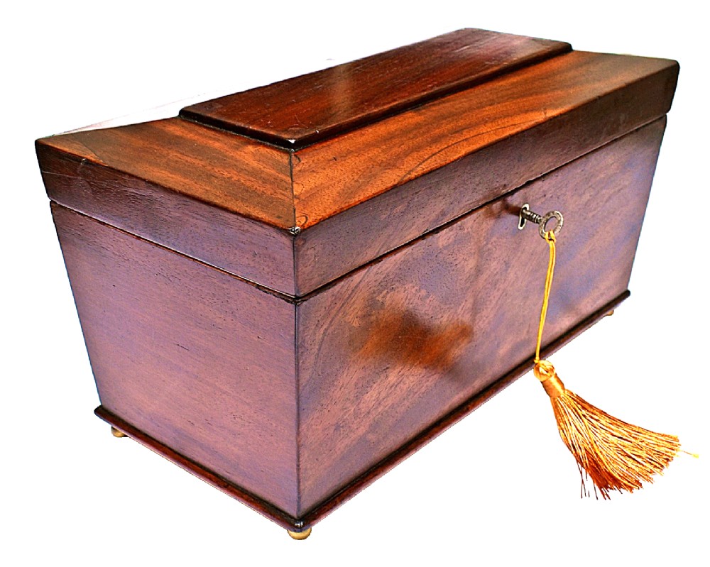 An open Victorian mahogany sarcophagus-shaped tea caddy featuring two lidded compartments, a central cut glass mixing bowl, marbled paper lid lining, and a key with a golden tassel. View III