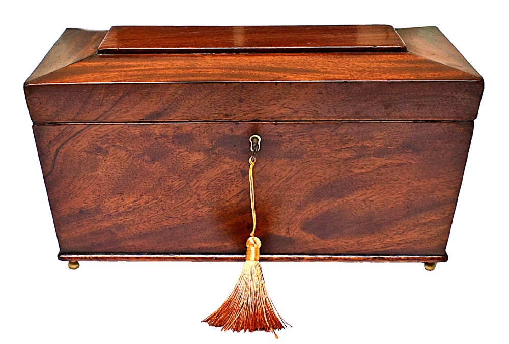 An open Victorian mahogany sarcophagus-shaped tea caddy featuring two lidded compartments, a central cut glass mixing bowl, marbled paper lid lining, and a key with a golden tassel. View V