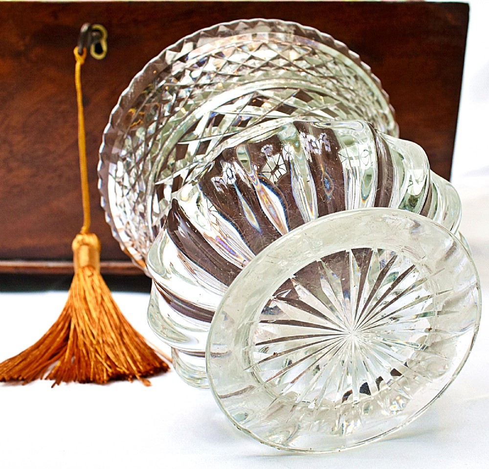 An open Victorian mahogany sarcophagus-shaped tea caddy featuring two lidded compartments, a central cut glass mixing bowl, marbled paper lid lining, and a key with a golden tassel. View IX