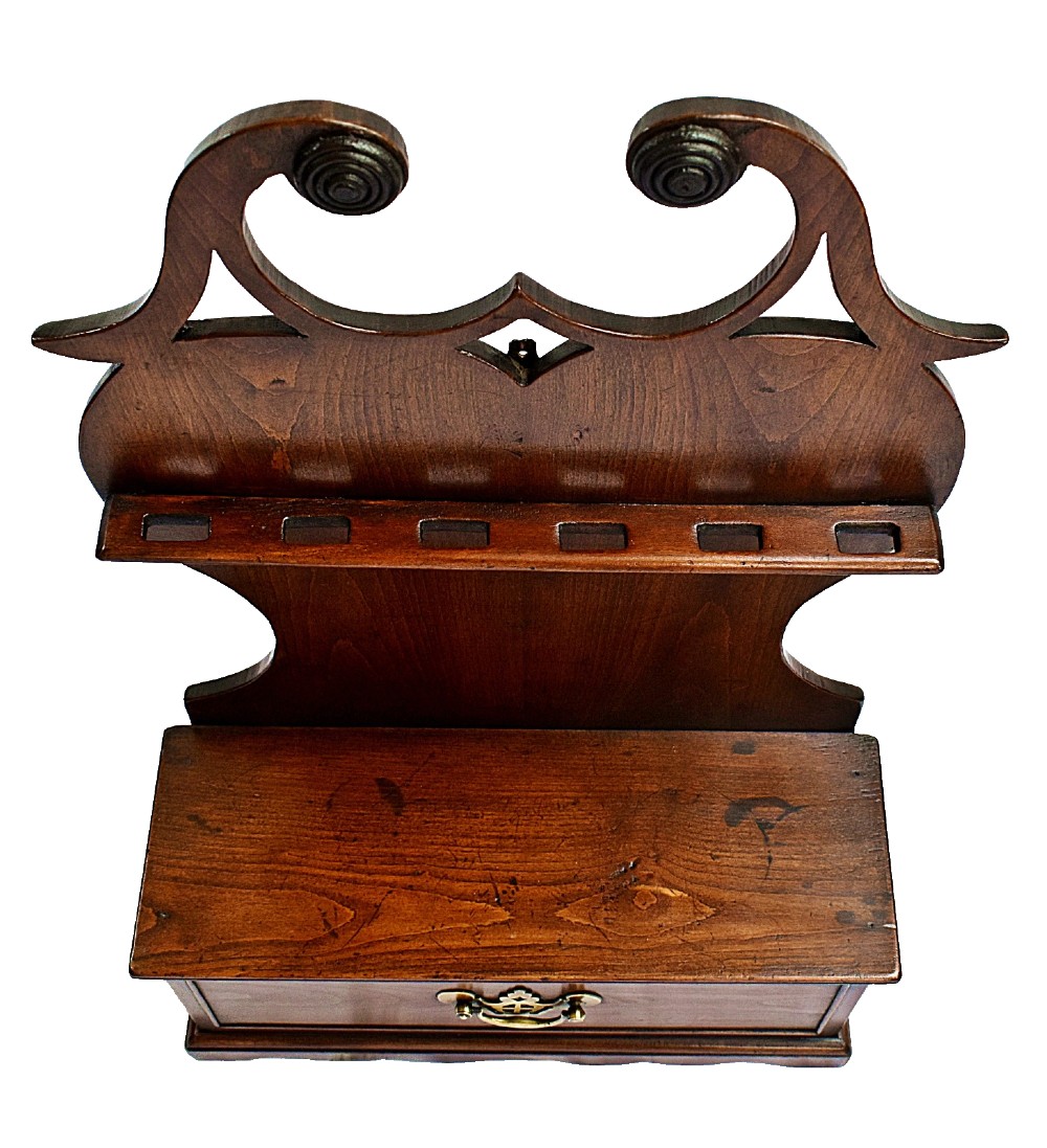 An antique carved oak spoon rack features a shaped scroll crest, a slotted rack, and a lower drawer with a brass drop handle. View IV