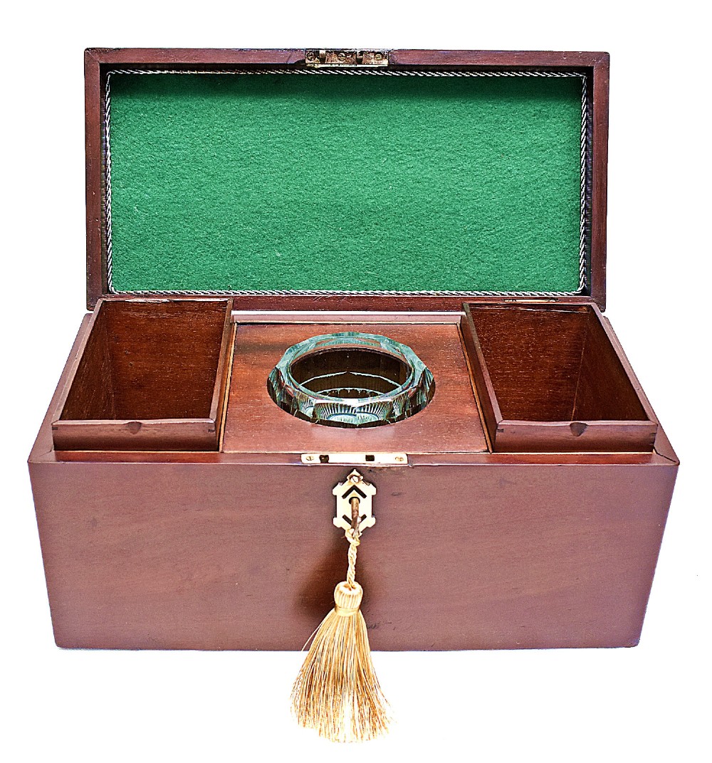 An open rectangular dark wood tea caddy featuring two internal covered compartments, a central cut glass mixing bowl, a green fabric-lined lid, and a key with a tassel inserted in the front lock. View III