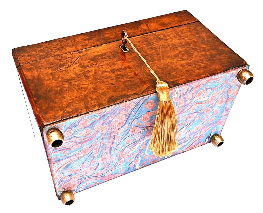 A rectangular mid-Victorian tea caddy crafted from figured burr walnut veneer with a central brass keyhole escutcheon and key. View VII