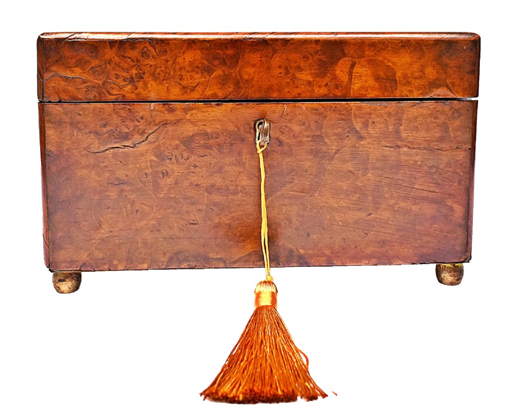 A rectangular mid-Victorian tea caddy crafted from figured burr walnut veneer with a central brass keyhole escutcheon and key. View IX