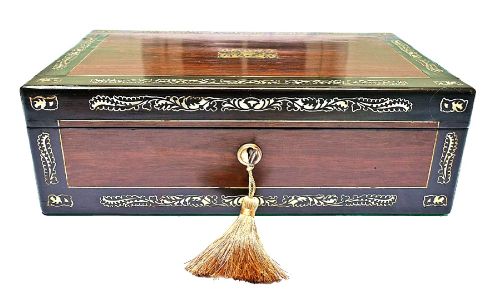 A dark rosewood writing slope with intricate mother-of-pearl floral inlays along the borders and a brass key with tassel attached to the front lock.