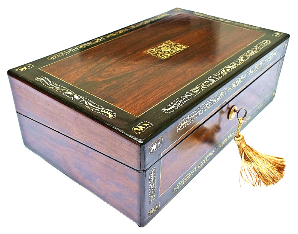 A dark rosewood writing slope with intricate mother-of-pearl floral inlays along the borders and a brass key with tassel attached to the front lock. View V