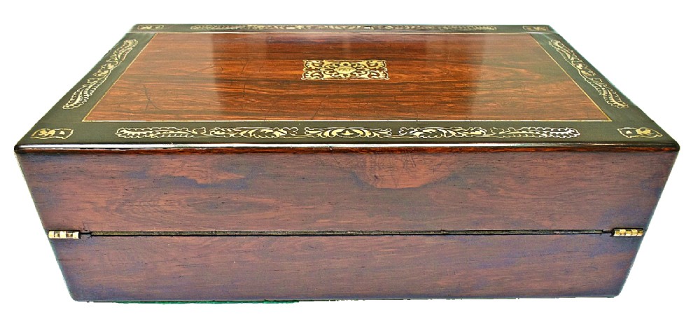 A dark rosewood writing slope with intricate mother-of-pearl floral inlays along the borders and a brass key with tassel attached to the front lock. View VI