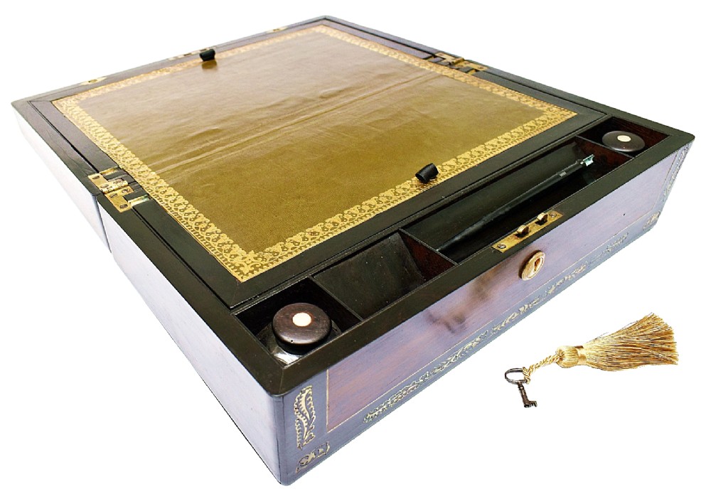 A dark rosewood writing slope with intricate mother-of-pearl floral inlays along the borders and a brass key with tassel attached to the front lock. View VII