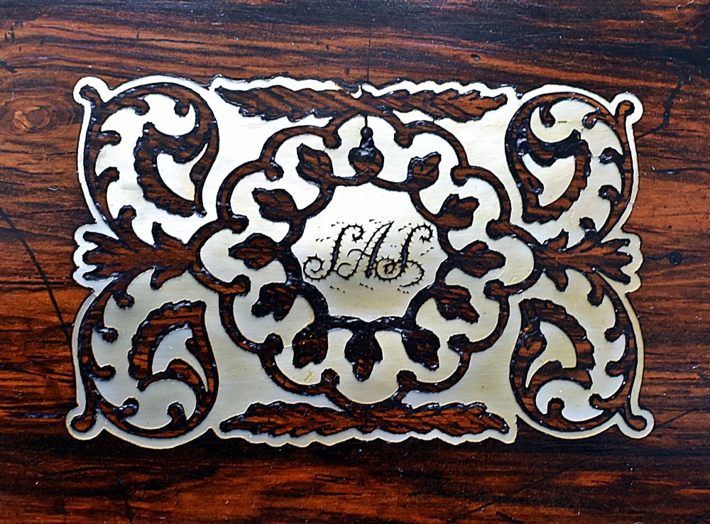 A dark rosewood writing slope with intricate mother-of-pearl floral inlays along the borders and a brass key with tassel attached to the front lock. View XIV