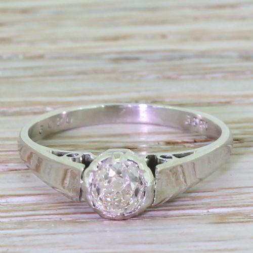 fig 1. An Art Deco solitaire ring crafted in white metal featuring a central round old cut diamond within a pierced gallery.