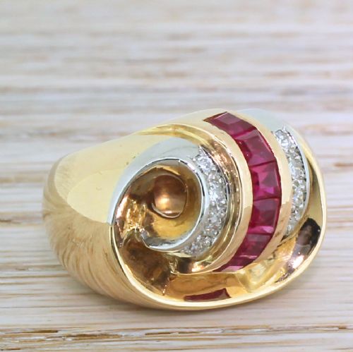 fig 2. A French mid-century yellow gold cocktail ring featuring a central channel of square red synthetic rubies flanked by diamond-set bands.