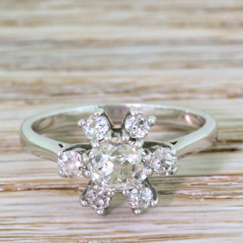 fig 1. A French mid-century white metal ring set with a central old cut diamond surrounded by a floral halo of seven smaller diamonds.