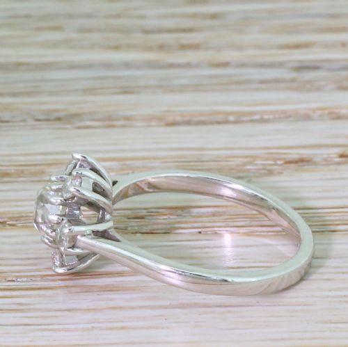 fig 2. A French mid-century white metal ring set with a central old cut diamond surrounded by a floral halo of seven smaller diamonds.