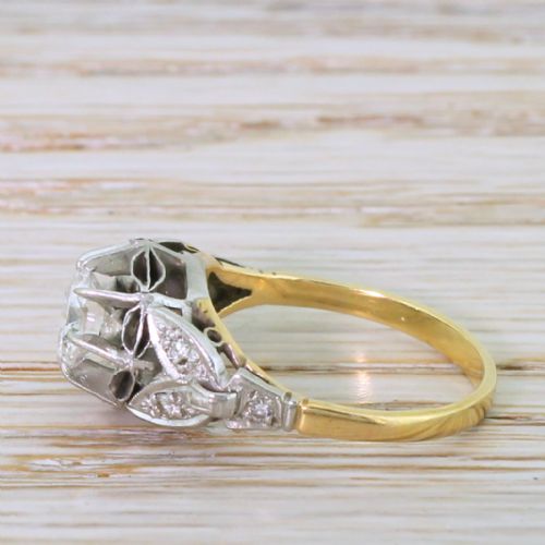 fig 2. A mid-century engagement ring featuring a transitional cut diamond set in a white metal head with carved shoulder accents on an 18ct yellow gold band.