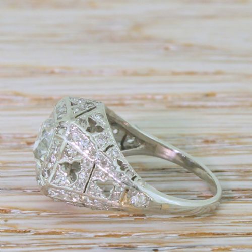 fig 2. An Art Deco platinum ring featuring a central cushion-shaped old cut diamond set within an openwork dome of pierced filigree and accent diamonds.