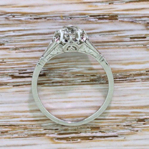 fig 2. An Art Deco diamond ring featuring a central round old cut diamond in a fluted platinum setting with geometric shoulders.