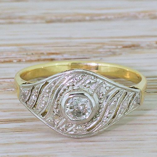 fig 1. An Art Deco yellow gold ring featuring a platinum swirl face set with a central round old cut diamond and detailed milgrain edging.