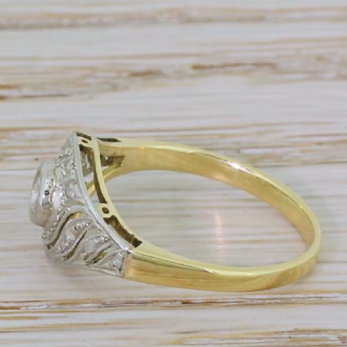fig 2. An Art Deco yellow gold ring featuring a platinum swirl face set with a central round old cut diamond and detailed milgrain edging.