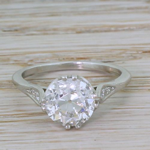 fig 1. An Art Deco platinum solitaire ring set with a central old cut diamond and accent diamonds set into carved shoulders.