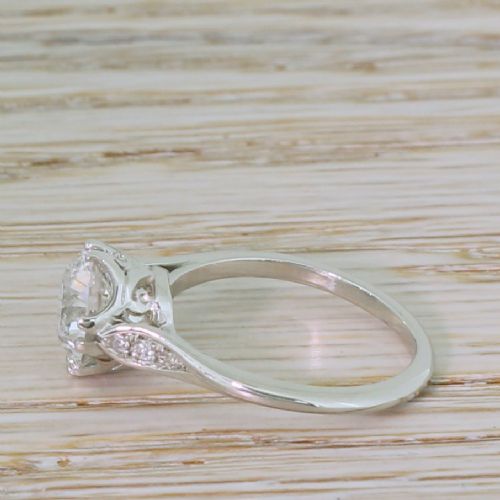 fig 2. An Art Deco platinum solitaire ring set with a central old cut diamond and accent diamonds set into carved shoulders.