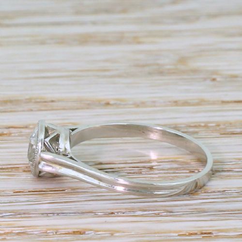 fig 2. An Art Deco solitaire engagement ring featuring a round old cut diamond set in a milgrained rubover bezel on a platinum band.