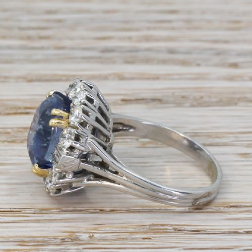 fig 2. A mid-century cluster ring featuring a central oval blue sapphire surrounded by round brilliant and baguette diamonds set in platinum.