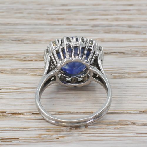 fig 3. A mid-century cluster ring featuring a central oval blue sapphire surrounded by round brilliant and baguette diamonds set in platinum.