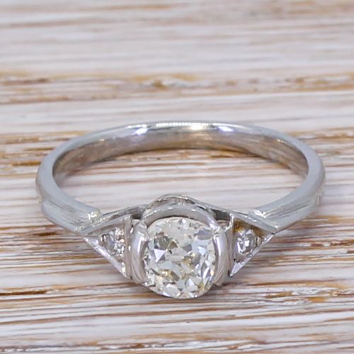fig 1. An Art Deco engagement ring featuring a central round old cut diamond set in a platinum band with triangular geometric shoulders.