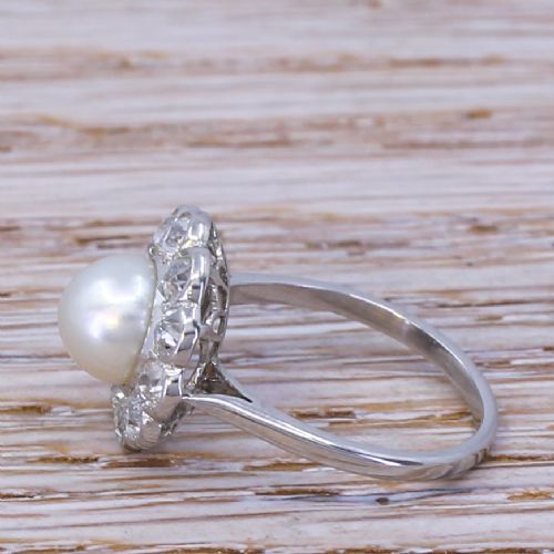 fig 2. An Art Deco ring featuring a central white natural pearl surrounded by a scalloped halo of old cut diamonds set in white metal.