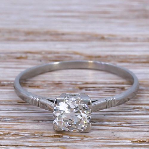 fig 1. An Art Deco diamond ring featuring a single old cut diamond set in a square metal mounting on a slender band.